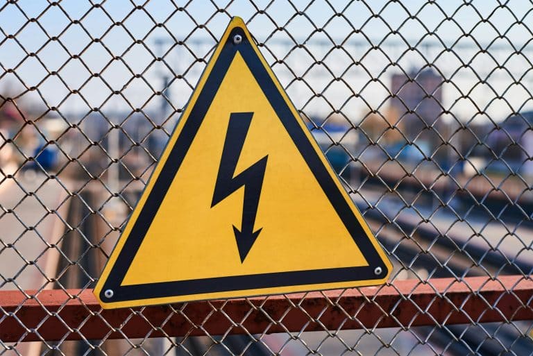 Emergency Electrical Services hazard sign. High voltage electricity on a railway station
