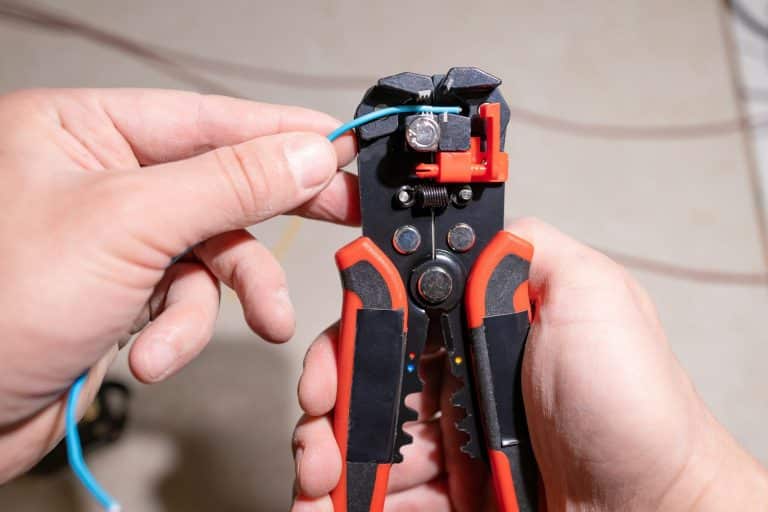man works with electrical wires using tools, fixing socket at home, male household work with electri